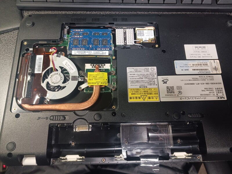 Dell Latitude 3500ノートパソコンの内部構造。マザーボード、DDRメモリスロット、冷却ファン、バッテリーが見える開けられた状態の写真